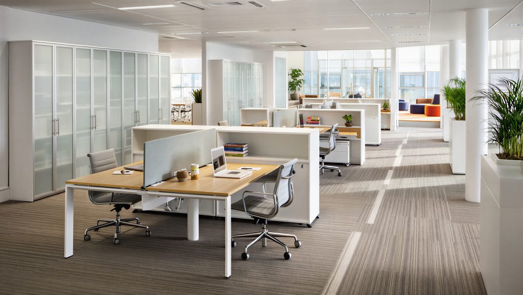 Bright Open Plan Office With White Workstations And Warm Striped Carpet